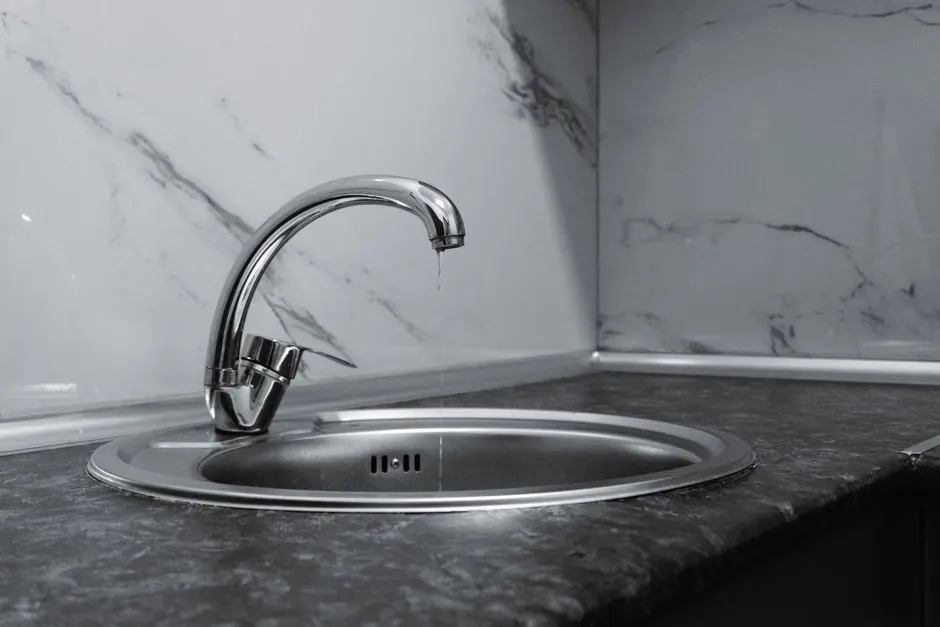 A clean and modern kitchen sink with a chrome faucet, highlighting minimalist design and water conservation.
